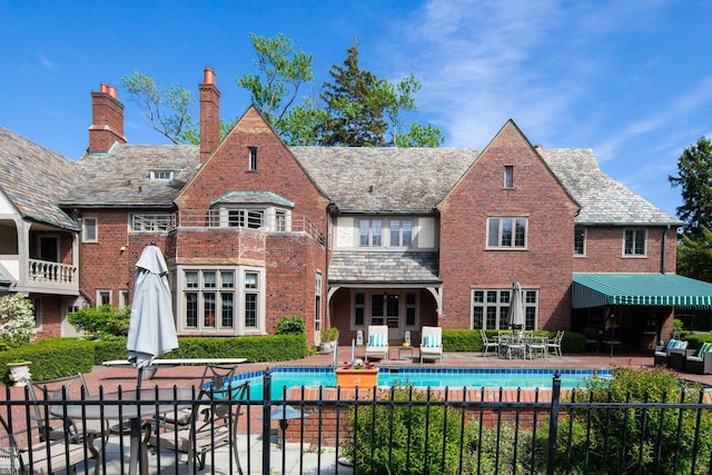 257 Ridge Rd, Grosse Pointe Farms, MI 48236 - rear view of house with a high end roof, a chimney, and brick siding