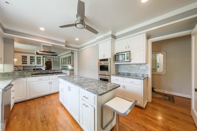 257 Ridge Rd, Grosse Pointe Farms, MI 48236 - kitchen with appliances with stainless steel finishes, ceiling fan, a center island, backsplash, and light wood-type flooring