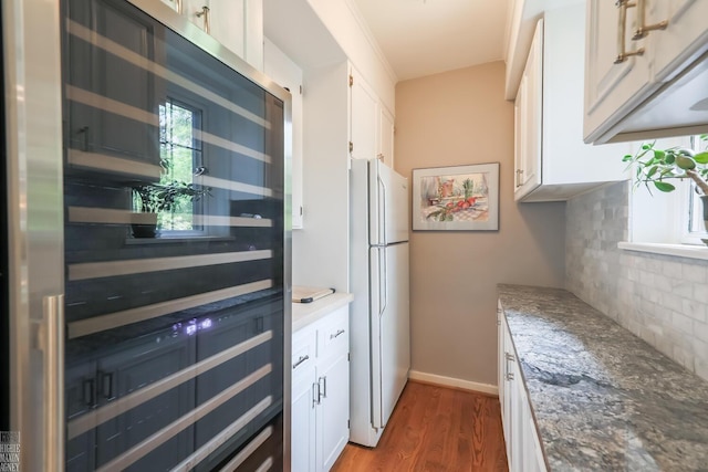 257 Ridge Rd, Grosse Pointe Farms, MI 48236 - kitchen with freestanding refrigerator, tasteful backsplash, dark wood-style flooring, white cabinetry, and stone counters