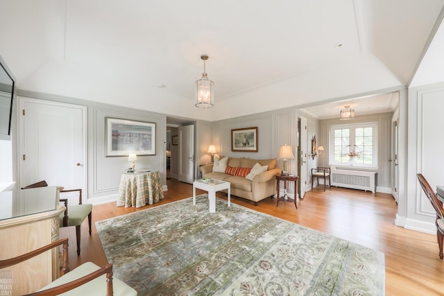 257 Ridge Rd, Grosse Pointe Farms, MI 48236 - living area featuring radiator heating unit, a decorative wall, light wood-style flooring, and a chandelier