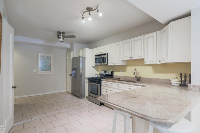 257 Ridge Rd, Grosse Pointe Farms, MI 48236 - kitchen with appliances with stainless steel finishes, a sink, a breakfast bar, a ceiling fan, and white cabinets