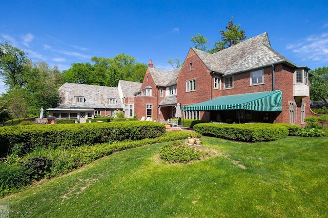 257 Ridge Rd, Grosse Pointe Farms, MI 48236 - back of house with a high end roof, brick siding, a yard, and a chimney