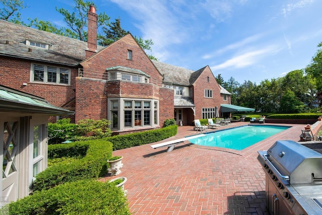 257 Ridge Rd, Grosse Pointe Farms, MI 48236 - swimming pool featuring a diving board and a patio area