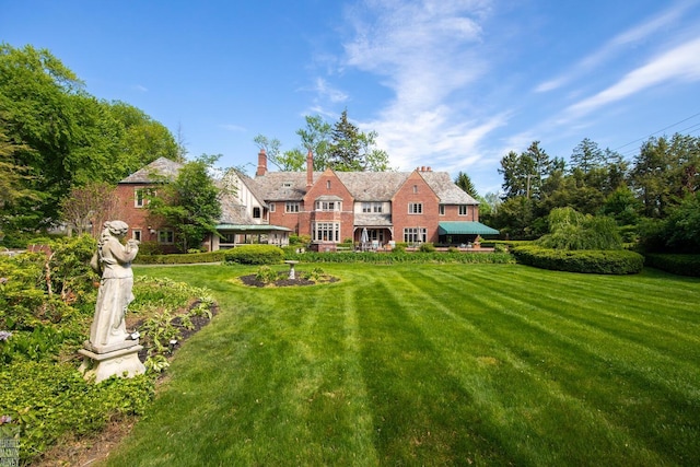 257 Ridge Rd, Grosse Pointe Farms, MI 48236 - rear view of property with a lawn and a chimney