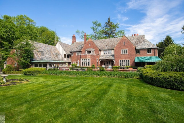 257 Ridge Rd, Grosse Pointe Farms, MI 48236 - back of property with a high end roof, a lawn, a chimney, and stone siding
