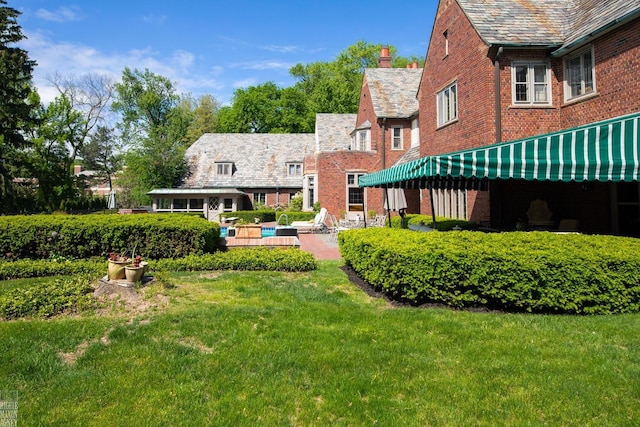 257 Ridge Rd, Grosse Pointe Farms, MI 48236 - back of house featuring a high end roof, brick siding, a lawn, and a chimney