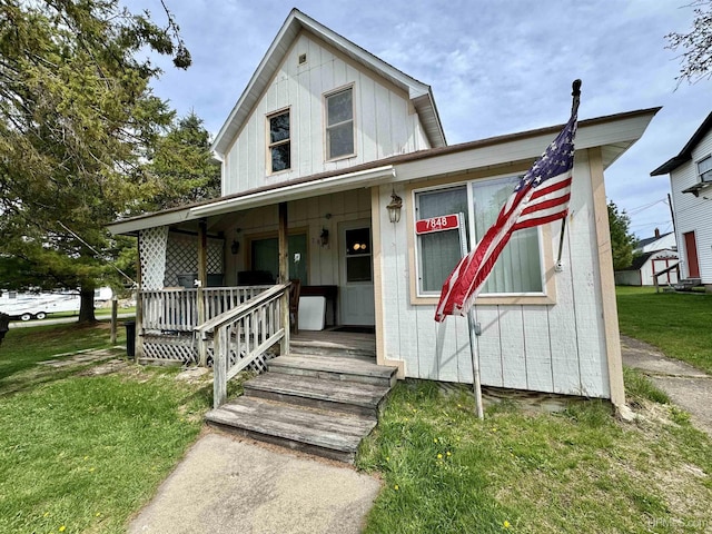 7848 Cole St, Rapid River, MI 49878 - view of front of house featuring a porch and a front lawn