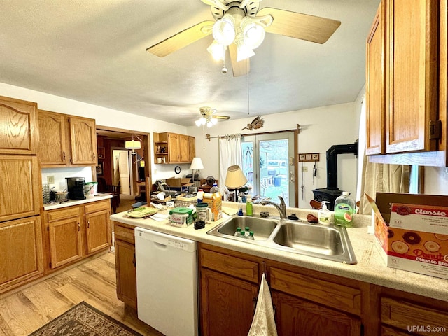 7848 Cole St, Rapid River, MI 49878 - kitchen featuring white dishwasher, a sink, ceiling fan, light wood finished floors, and light countertops