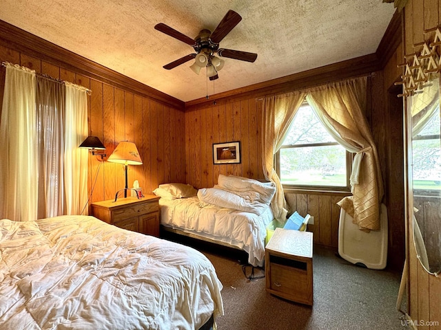 7848 Cole St, Rapid River, MI 49878 - carpeted bedroom featuring a textured ceiling, wood walls, and ceiling fan