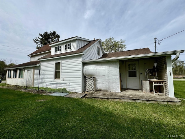 7848 Cole St, Rapid River, MI 49878 - back of property featuring a lawn and roof with shingles