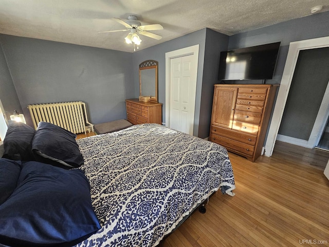 968 Baldwin Ave, Negaunee, MI 49866 - bedroom with wood finished floors, ceiling fan, baseboards, a closet, and a textured ceiling