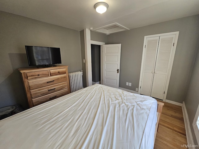 968 Baldwin Ave, Negaunee, MI 49866 - bedroom with radiator, attic access, wood finished floors, baseboards, and a closet