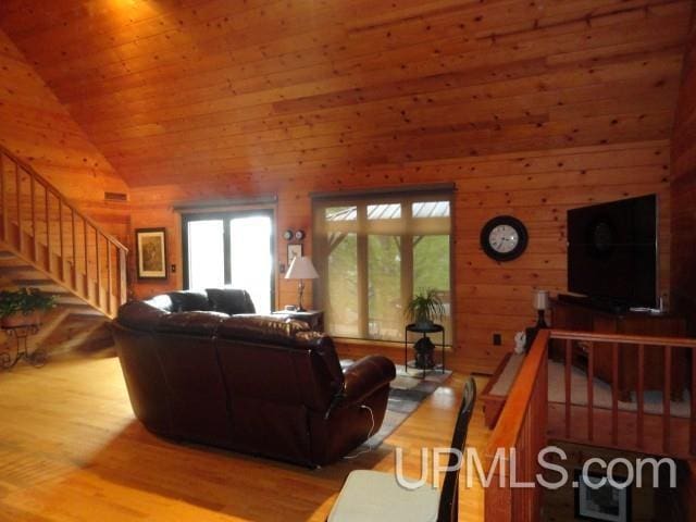 1417 Nestor St, Munising, MI 49862 - living room featuring wood finished floors, stairs, wood walls, wooden ceiling, and high vaulted ceiling