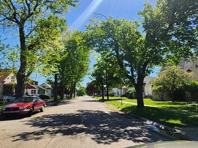 2515 Cooper St, Saginaw, MI 48602 - view of asphalt street featuring a residential view, curbs, sidewalks, and traffic signs