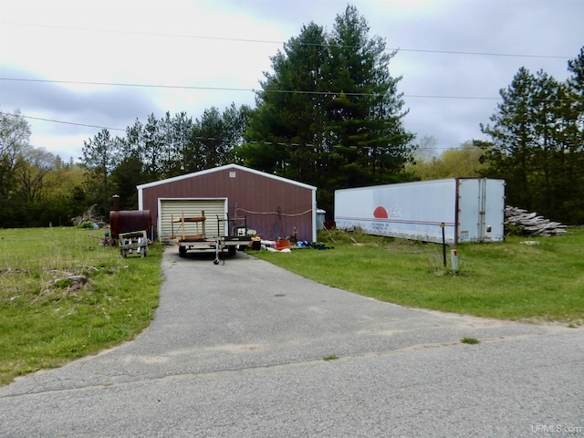 4815 N Southside Rd, Manistique, MI 49854 - view of front of home featuring a detached garage, driveway, an outdoor structure, and a front yard