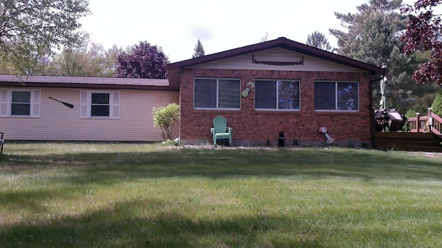 4158 Scott Ct, Gladwin, MI 48624 - rear view of property featuring brick siding, a yard, and a deck