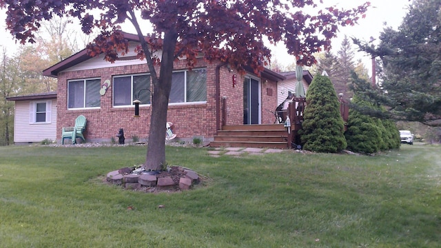 4158 Scott Ct, Gladwin, MI 48624 - view of property exterior with a deck, a lawn, and brick siding