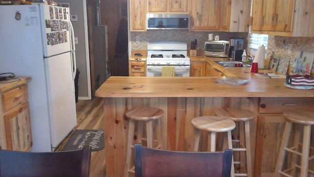 4158 Scott Ct, Gladwin, MI 48624 - kitchen with white appliances, a sink, decorative backsplash, and butcher block counters