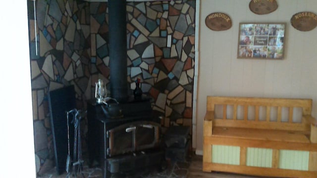 4158 Scott Ct, Gladwin, MI 48624 - living area with a wood stove, wood finished floors, and radiator