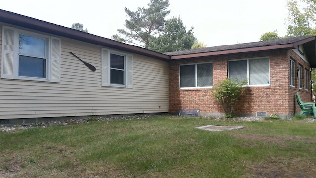 4158 Scott Ct, Gladwin, MI 48624 - view of side of home featuring brick siding and a yard