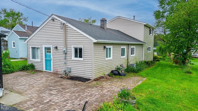 656 Lawson Dr, Lake Orion, MI 48362 - rear view of house with a patio area, a yard, a chimney, a shingled roof, and central AC unit