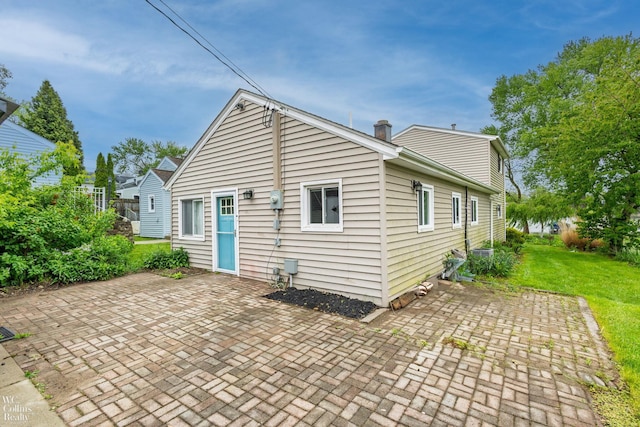 656 Lawson Dr, Lake Orion, MI 48362 - rear view of house with a patio, a lawn, and a chimney