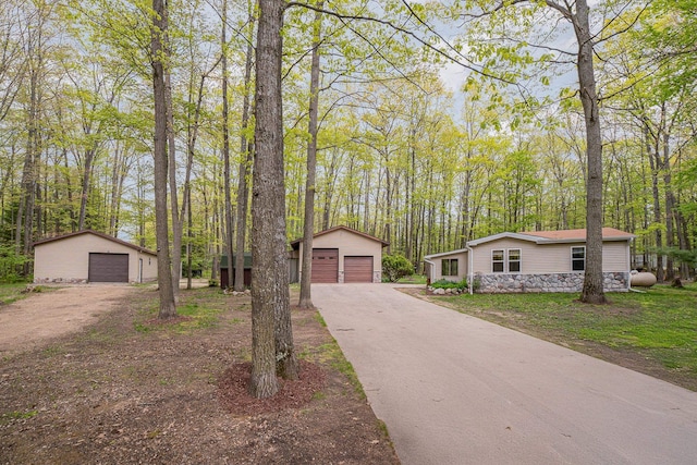 122 Shady Grove Ln, Roscommon, MI 48653 - mid-century inspired home with a garage, an outbuilding, and a forest view