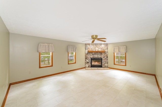 122 Shady Grove Ln, Roscommon, MI 48653 - unfurnished living room featuring ceiling fan, baseboards, a stone fireplace, and light floors
