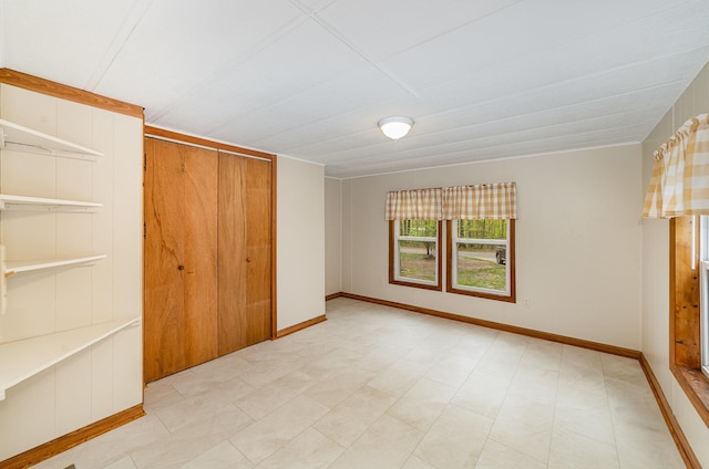 122 Shady Grove Ln, Roscommon, MI 48653 - unfurnished bedroom featuring a closet and baseboards