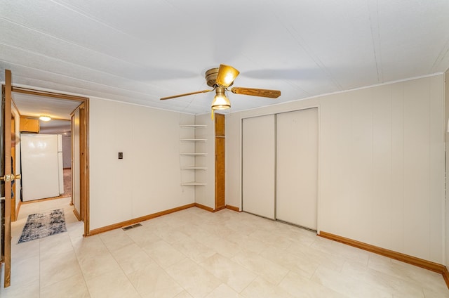122 Shady Grove Ln, Roscommon, MI 48653 - unfurnished bedroom with freestanding refrigerator, baseboards, a ceiling fan, and a closet