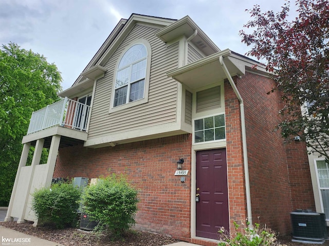 15495 Cornell Dr, Clinton Township, MI 48038 - view of front facade featuring central AC unit, brick siding, and a balcony