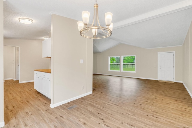 2100 Rowe Rd, Applegate, MI 48401 - spare room with a chandelier, light wood finished floors, and baseboards