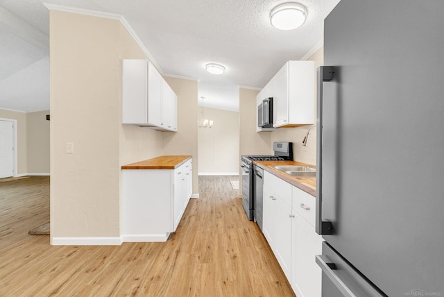 2100 Rowe Rd, Applegate, MI 48401 - kitchen with appliances with stainless steel finishes, crown molding, butcher block countertops, light wood-style flooring, and white cabinets
