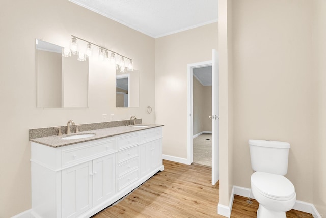 2100 Rowe Rd, Applegate, MI 48401 - full bathroom with double vanity, ornamental molding, wood finished floors, toilet, and baseboards