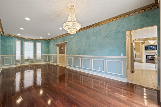 4931 Peggy St, West Bloomfield, MI 48322 - spare room with ornamental molding, a wainscoted wall, hardwood / wood-style flooring, wallpapered walls, and a chandelier