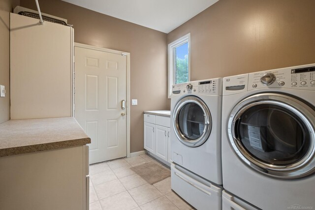 4931 Peggy St, West Bloomfield, MI 48322 - washroom with washing machine and clothes dryer, cabinet space, light tile patterned floors, and baseboards
