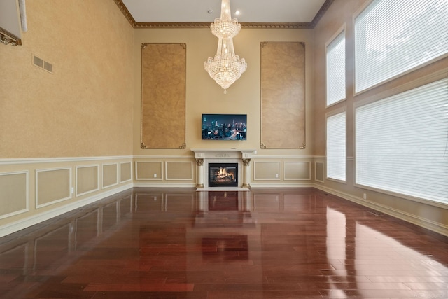 4931 Peggy St, West Bloomfield, MI 48322 - unfurnished living room featuring a chandelier, wood finished floors, a glass covered fireplace, a decorative wall, and ornamental molding