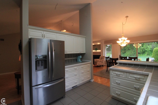 50887 Nature Dr, New Baltimore, MI 48047 - kitchen featuring stainless steel refrigerator with ice dispenser, tile countertops, a chandelier, white cabinets, and dark tile patterned flooring