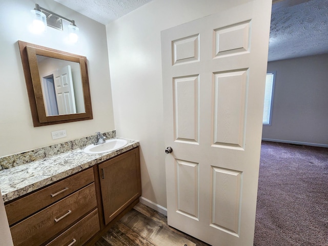 2521 Bonnie Mae Rd, Harrison, MI 48625 - bathroom with a textured ceiling, vanity, and baseboards