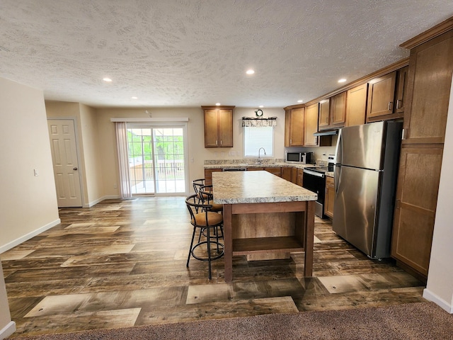 2521 Bonnie Mae Rd, Harrison, MI 48625 - kitchen featuring appliances with stainless steel finishes, a textured ceiling, a kitchen island, recessed lighting, and light countertops