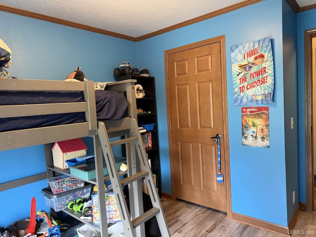 245 Silver Creek Rd, Marquette, MI 49855 - bedroom with wood finished floors, ornamental molding, a textured ceiling, and baseboards