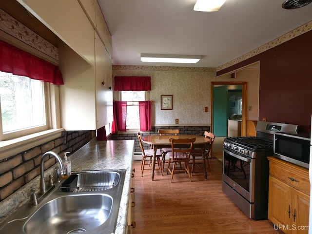 50 Baltic Ave, South Range, MI 49963 - kitchen featuring stainless steel appliances, a sink, plenty of natural light, wallpapered walls, and light wood finished floors