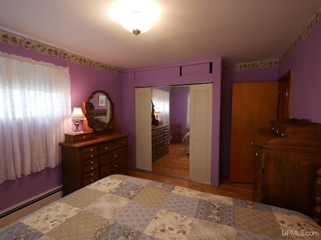 50 Baltic Ave, South Range, MI 49963 - bedroom featuring baseboard heating, a closet, and wood finished floors