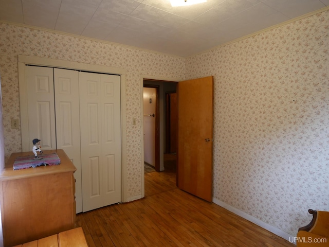 50 Baltic Ave, South Range, MI 49963 - bedroom with hardwood / wood-style flooring, wallpapered walls, crown molding, and a closet