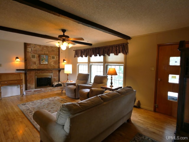 50 Baltic Ave, South Range, MI 49963 - living area with beam ceiling, ceiling fan, hardwood / wood-style flooring, a textured ceiling, and a stone fireplace