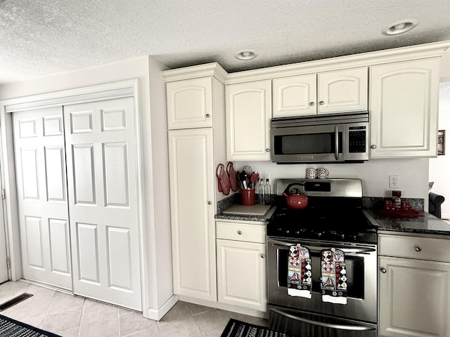 2684 Lakeshore Dr, Gladwin, MI 48624 - kitchen with stainless steel appliances, dark countertops, white cabinetry, a textured ceiling, and recessed lighting