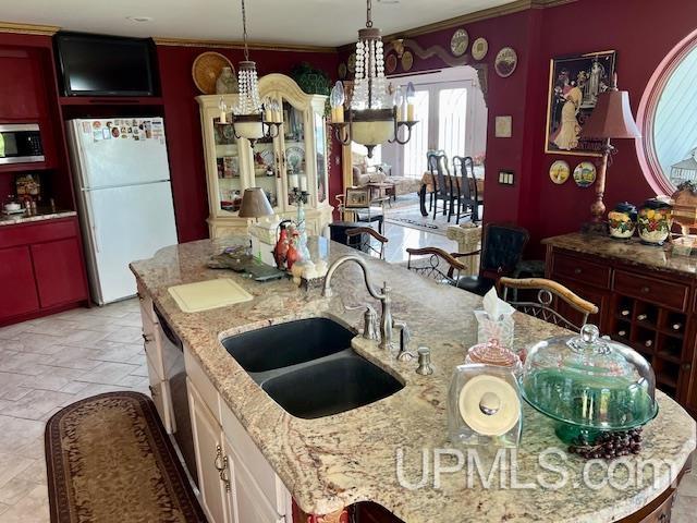 9411 Goodell Rd, Eagle Harbor, MI 49950 - kitchen with freestanding refrigerator, stainless steel microwave, a sink, a chandelier, and ornamental molding
