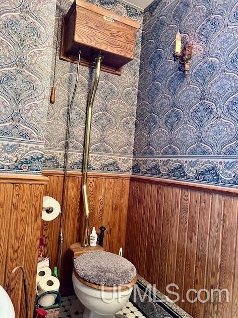 9411 Goodell Rd, Eagle Harbor, MI 49950 - bathroom with wallpapered walls, toilet, a wainscoted wall, and wooden walls