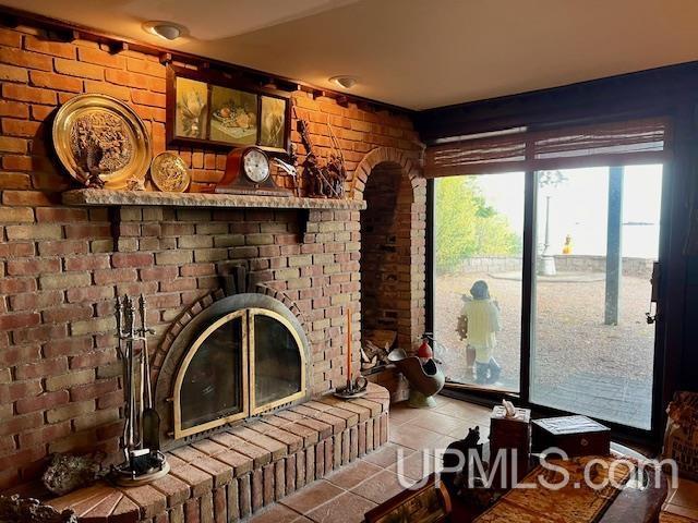 9411 Goodell Rd, Eagle Harbor, MI 49950 - living area with tile patterned flooring and brick wall