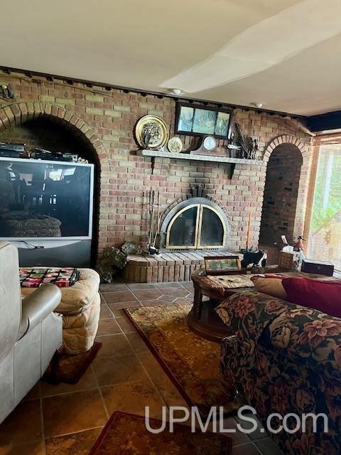 9411 Goodell Rd, Eagle Harbor, MI 49950 - tiled living room featuring brick wall and a fireplace